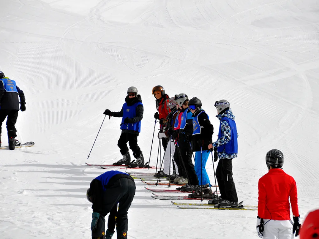 Jugendliche schnallen ihre Ski an.